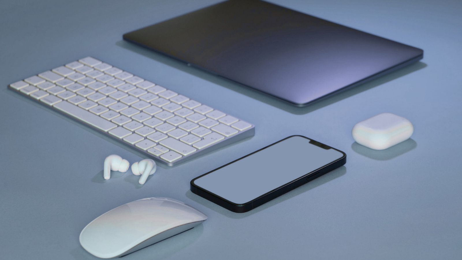 Modern laptop, smartphone, wireless earbuds, and keyboard arranged on a desk, representing hardware-native AI and on-device intelligence.