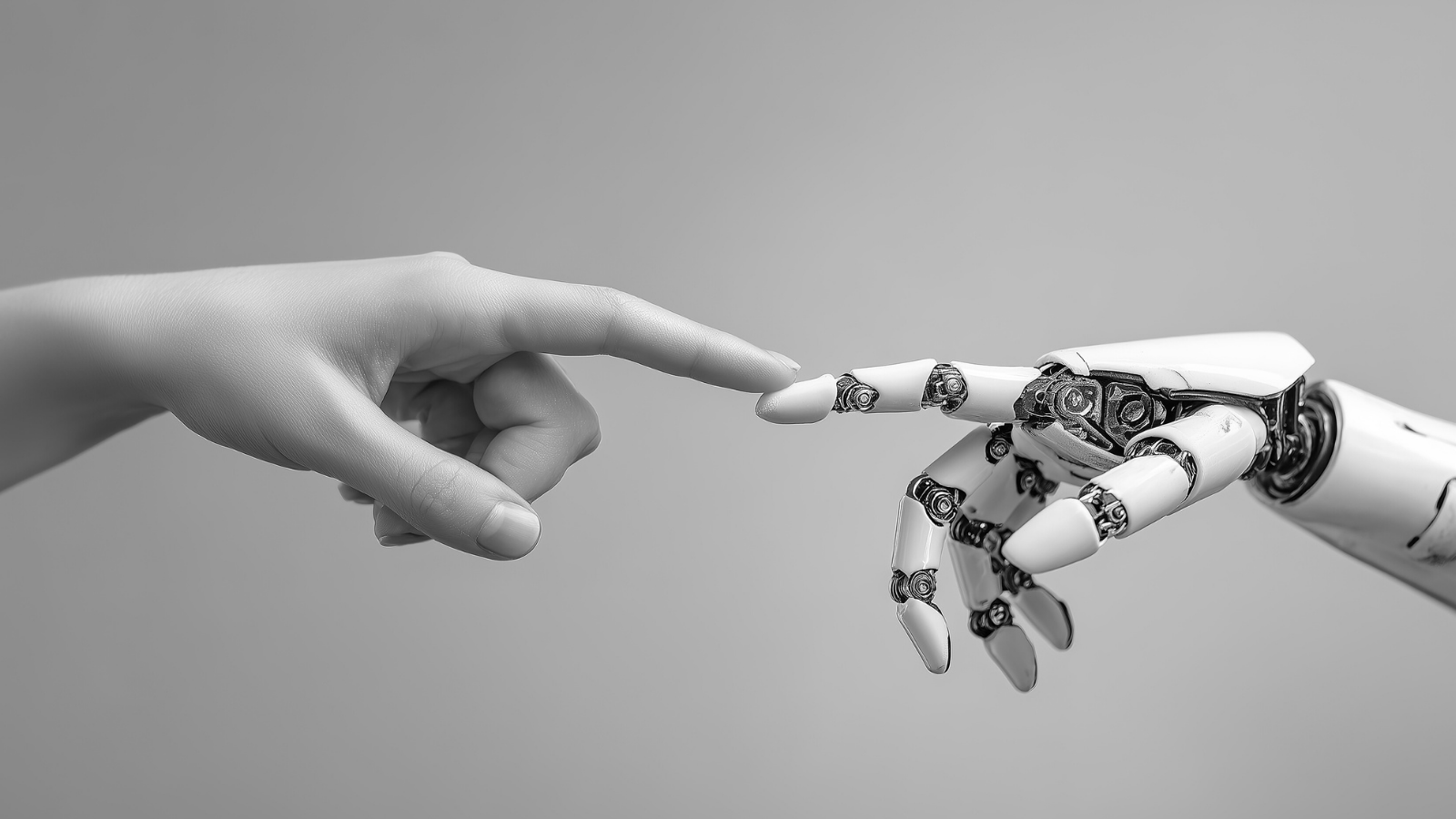 Black and white image of a human hand touching a robotic hand symbolizing human and artificial intelligence collaboration.