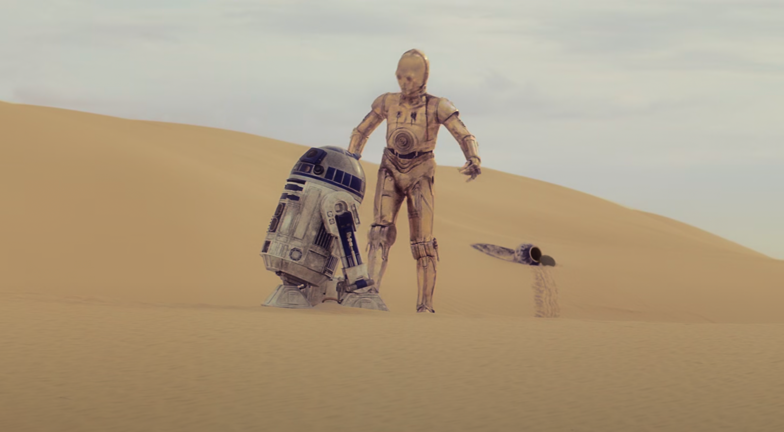 C-3PO and R2-D2 standing in a rocky desert landscape representing the gap between fictional and real world robotics